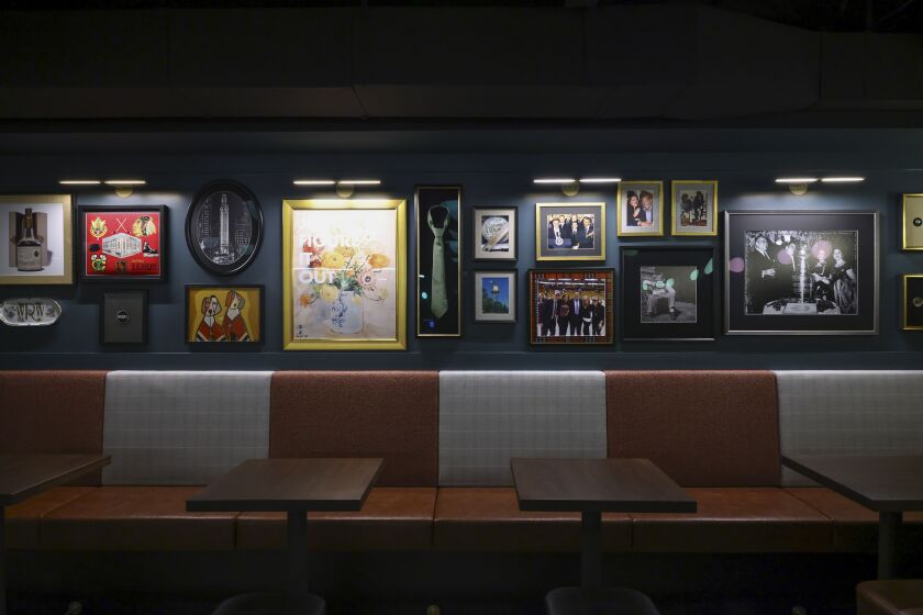 Photos of Rocky Wirtz, former owner and chairman of the Blackhawks, line the wall at the Blackhawks at the newly unveiled Rocky’s Bar in honor of Rocky Wirtz at the United Center, Tuesday, Dec. 19, 2023.