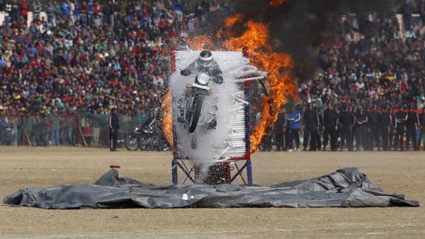 A Jammu and Kashmir state policeman performs a motorcycle stunt during Republic Day parade in Jammu, India, Monday, Jan. 26, 2015. Republic Day marks the anniversary of Indias democratic constitution taking force in 1950. (AP Photo/Channi Anand)