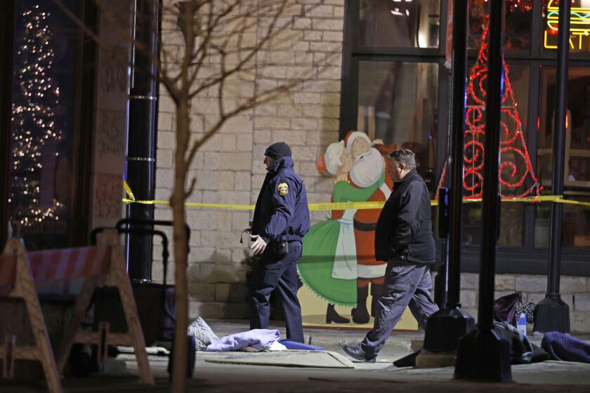 Police investigators in downtown Waukesha, Wis., after an SUV plowed into a parade of Christmas marchers, killing multiple people Sunday, Nov. 21, 2021.