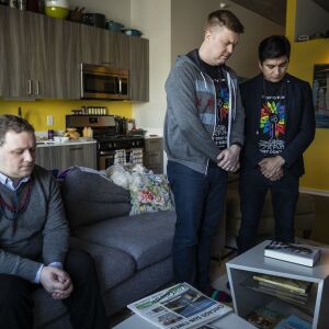 Matt Schreck, 43, his husband, Fernando Gutierrez, 41, and their friend Brian Dowling, 39, bow their heads during a moment of silence for COVID-19 victims during the inauguration ceremony for President Joe Biden and Vice President Kamala Harris at Schreck and Gutierrez’s South Loop home, Wednesday morning, Jan. 20, 2021.