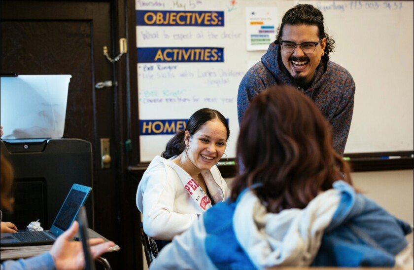 Josh Zepeda, a social worker at Sullivan High School in Rogers Park, shares a laugh with students in a class for those who speak little or no English.