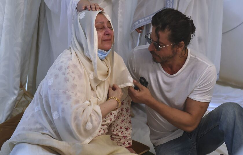 Actor Shahrukh Khan (right) consoles Saira Banu as she mourns death of her husband and Bollywood icon Dilip Kumar at their residence in Mumbai, India, on Wednesday. Kumar, hailed as one of Hindi cinema’s greatest actors, died Wednesday in a Mumbai hospital after a prolonged illness. He was 98.