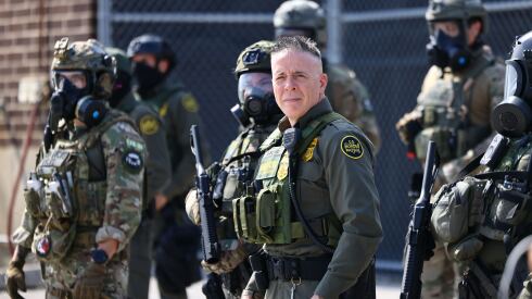 Gregory Bovino, chief patrol agent of the U.S. Border Patrol’s El Centro Sector who led ICE enforcement operations in Los Angeles, stands with law enforcement officers during a clash with protesters Friday outside the ICE facility in Broadview.