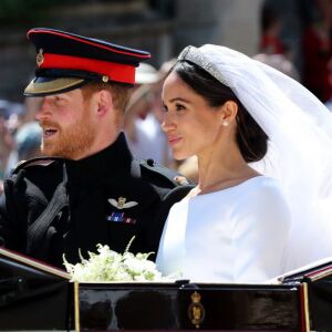Prince Harry, Duke of Sussex and his wife Meghan begin their carriage procession. | GARETH FULLER/AFP/Getty Images