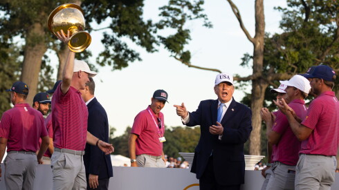 President Donald Trump cheers as USA Captain Brandt Snedeker holds up the trophy at the Presidents Cup golf tournament in suburban Medinah, Sunday, Sept. 27, 2026.