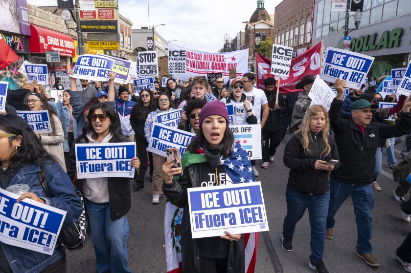 Protesters march westbound on 26th Street in Little Village on Saturday. One neighborhood resident said Little Village is like "a ghost town. Nobody is here, and our businesses are failing. Our people are being kidnapped."