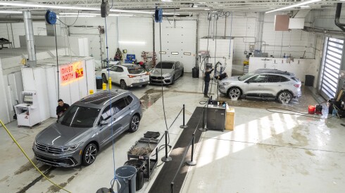 Employees at River North Collision Repair work on vehicles at the West Town auto shop.