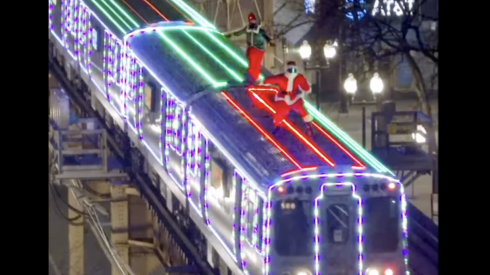 Someone dresses as Santa Claus, accompanied by somebody with an elf costume, are shown atop the CTA's holiday train in the Loop, apparently within the last week or so.