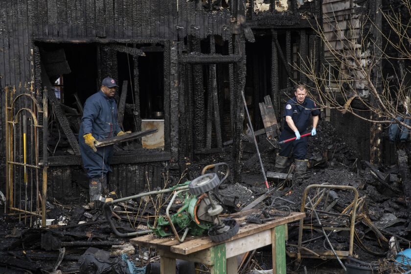 Chicago Fire Department firefighters work on a two-flat residential building in the 2500 block of South Albany Avenue that was destroyed by an extra-alarm blaze early Monday and spread to the two neighboring homes, leaving one firefighter injured.