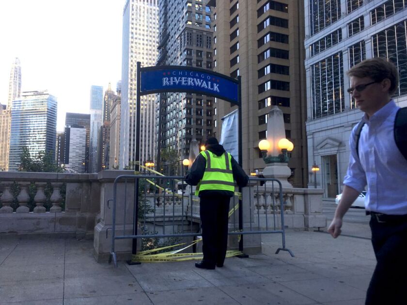 A security guard puts a barricade to seal off the steps to the Riveralk at Clark Street. | Stefano Esposito/Sun-Times