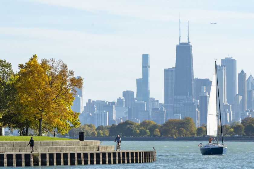 A sailboat moves into Montrose Harbor and people enjoy the Lakefront Trail on the North Side as temperatures climbed above 80 degrees, Tuesday, Oct. 24. The average high for Oct. 24 in the Chicago area is 59 degrees, according to the National Weather Service.