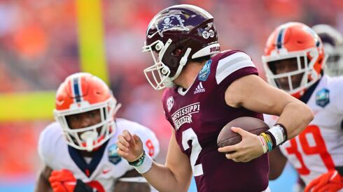 Illinois’ Tarique Barnes (left) and Kenenna Odeluga hound Mississippi State quarterback Will Rogers during the ReliaQuest Bowl in Tampa, Florida.