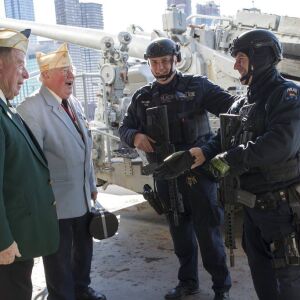 Veterans John Dunleavy, left, and Jim Mullarkey, speak to police officers on board the Intrepid in New York. | AP Photo