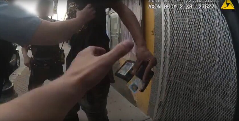 What appears to be a firearm owners identification card is visible in the moments before police shot Harith Augustus. | Screen shot from Chicago Police Video