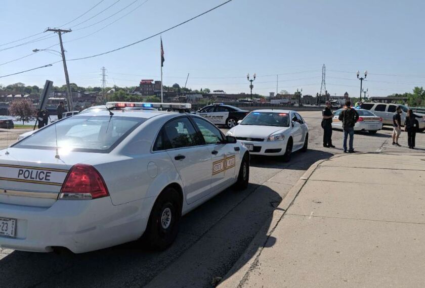 Police cars outside Dixon (Ill.) High School on Wednesday, where officials say a police officer shot and wounded a former student who had fired at him. He is in custody with what have been described as non-life-threatening injuries. | Rachel Rogers/Sauk V