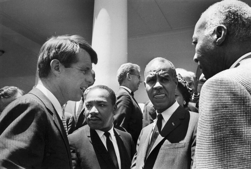 In this June 22, 1963, file photo, U.S. Attorney General Robert F. Kennedy (left) speaks with civil rights leaders Rev. Martin Luther King Jr. (from left), Roy Wilkins and A. Phillip Randolph on the White House grounds, in Washington, D.C. Civil rights la