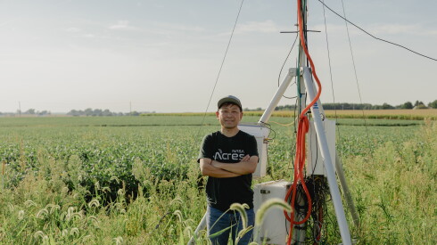 Kaiyu Guan in a field next to machinery