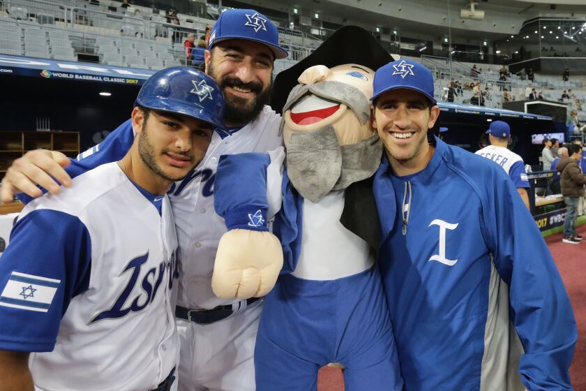 Israeli players pose for photographs with team mascot “The Mensch” after their 4-2 victory in the World Baseball Classic game against the Netherlands in Seoul, South Korea. | Chung Sung-Jun/Getty Images