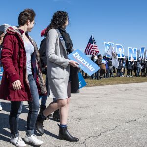 A group of Sanders supporters walk towards the stage to stake out a good spot, ahead of the Bernie Sanders rally, Saturday, March 7, 2020.