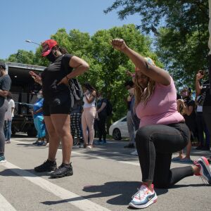A protester kneels to honor George Floyd during the Westside interfaith peace march on June 12, 2020 in North Lawndale.