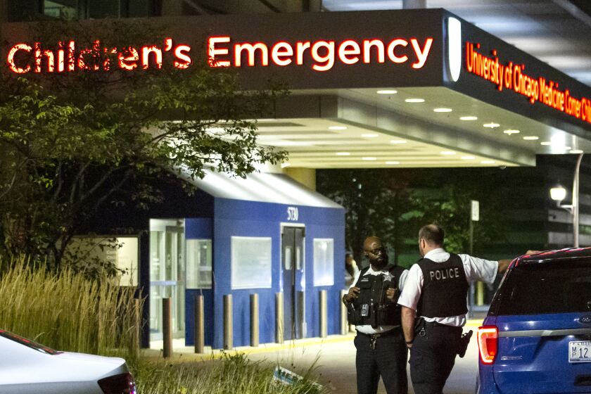 Chicago police personnel chat outside Comer Children’s Hospital on the South Side after a 4-year-old boy was shot in the head Friday night in the 6500 block of South Ellis Avenue in Woodlawn.