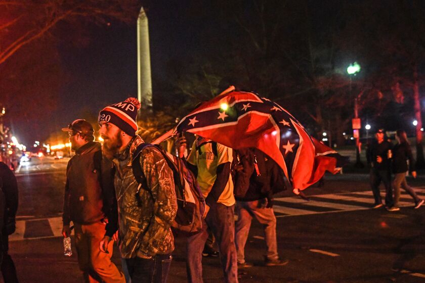 A supporter of President Donald Trump walks with a confederate flag during a protest on December 12, 2020 in Washington, DC.