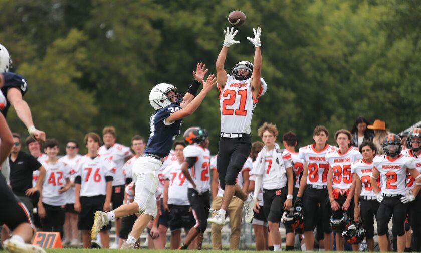 McHenry’s Joey Crowly (21) elevates to catch a pass despite the defense of Cary-Grove’s Jack Rocen (34).