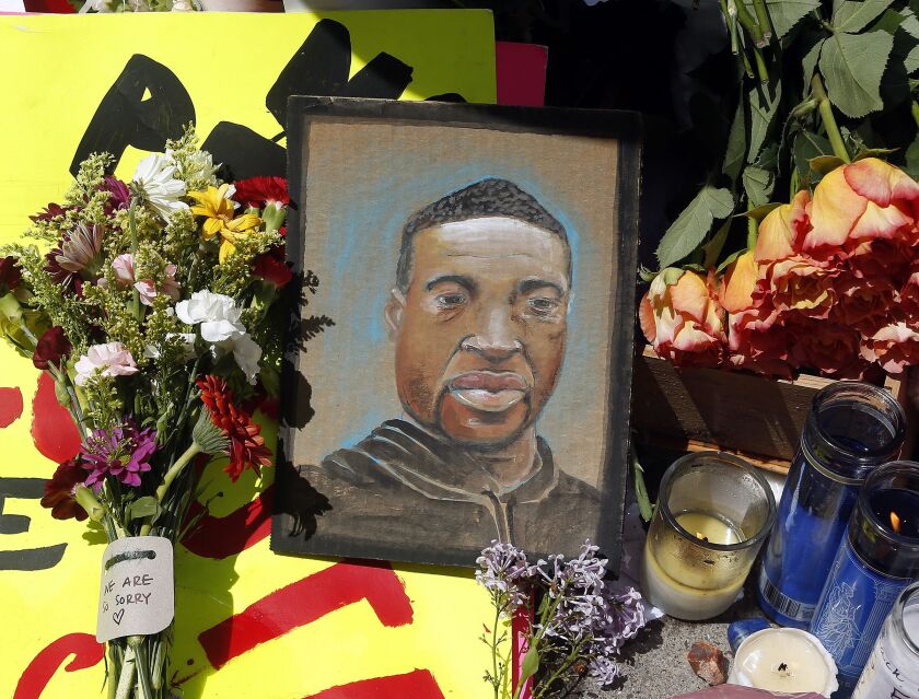 A portrait of George Floyd is part of the memorial for him near the site where he was arrested in Minneapolis. He died in police custody Monday night. A video shared online by a bystander showed a white officer kneeling on his neck during his arrest as he pleaded that he couldn’t breathe.