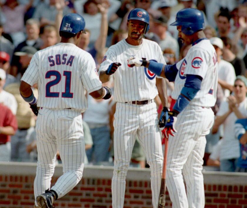 Chicago Cubs’ Doug Glanville, center, and Shawon Dunston, right, congratulate Sammy Sosa (21) after hitting a home run in the eighth inning Sunday, Aug. 24, 1997, in Chicago. Sosa’s home run help defeat the Expos 12-3. (AP Photo/Michael Conroy)