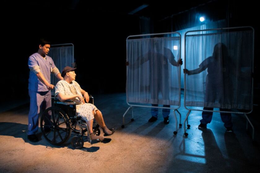 Kriydell Galima wheels Lisa Tejero in The Hypocrites’ production of Margaret Edson’s play “Wit.” (Photo: Joe Mazza)
