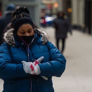 A woman puts on her gloves while walking down Wabash Ave. in The Loop, Friday afternoon, while temperatures were well below freezing, Friday, Jan. 25, 2019, in Chicago. | Tyler LaRiviere/Sun-Times