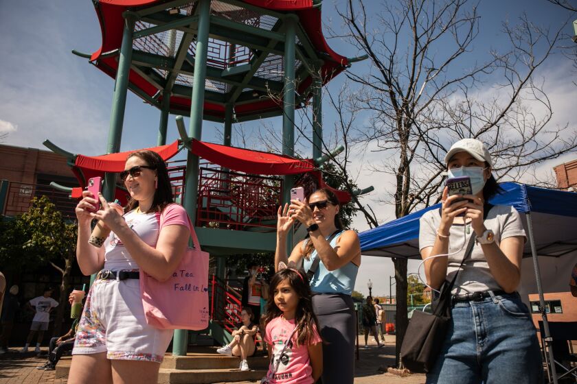 Spectators film K-pop fans as they participate in K-Pop Random Dance, where people jump into the circle to dance together whenever they hear songs they know the choreography to, during “Youth of Chinatown,” a three-day event featuring hip-hop and K-pop performances at Chinatown Square Plaza, Saturday, Aug. 27, 2022.