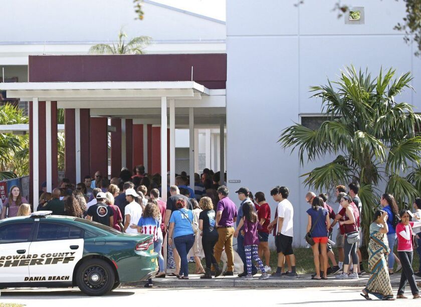 Parents and students walk into Marjory Stoneman Douglas High School on Sunday. | David Santiago/Miami Herald via AP