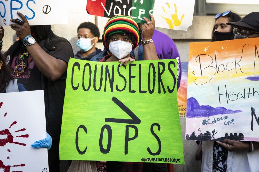 Activists in Voices of Youth in Chicago Education hold signs and rally June 16, 2020, outside City Hall about a Chicago City Council measure to terminate a $33 million contract between the Chicago Police Department and the Chicago Public Schools.