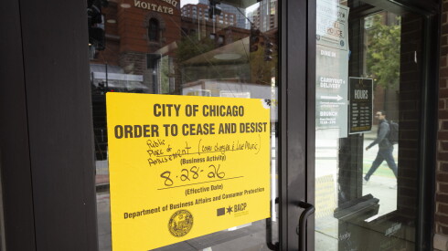 A yellow sign saying "City of Chicago order to cease and desist" is posted on the door of South Loop restaurant Reserv, 744 S. Dearborn St.