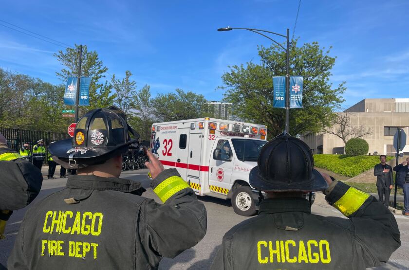 Members of the Chicago Fire Department salute as an ambulance carrying the body of a fallen police officer arrives at the Cook County Medical Examiner's Office.