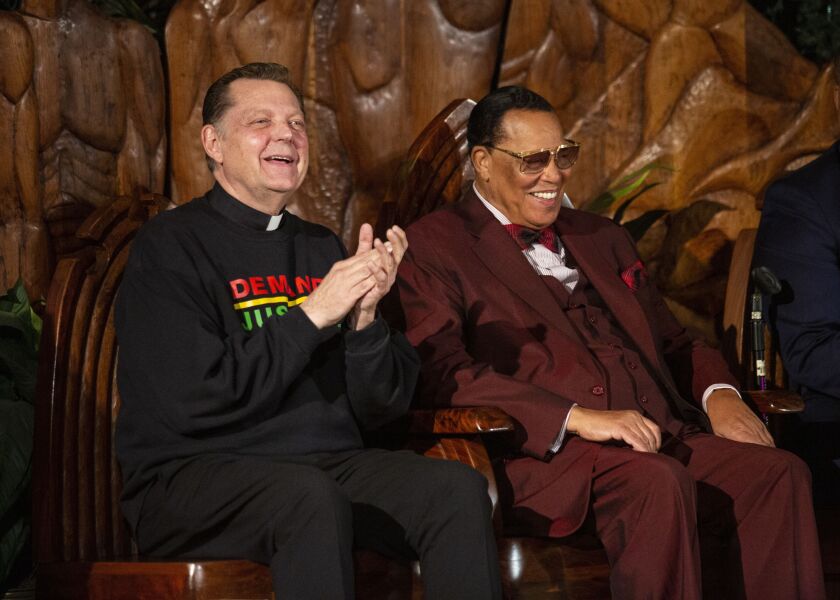 The Rev. Michael Pfleger sits next to Minister Louis Farrakhan at St. Sabina Church