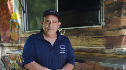 Caseras Sabor Real owner Ricardo Guerrero stands next to one of his food trucks.