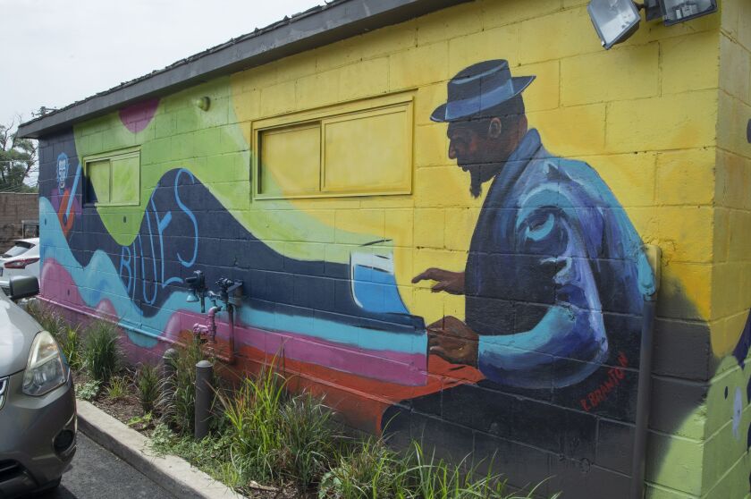 Paul Branton’s mural on the garage at Nicky’s of Beverly was inspired by blues music. It features a guitarist in one corner and a pianist in another.