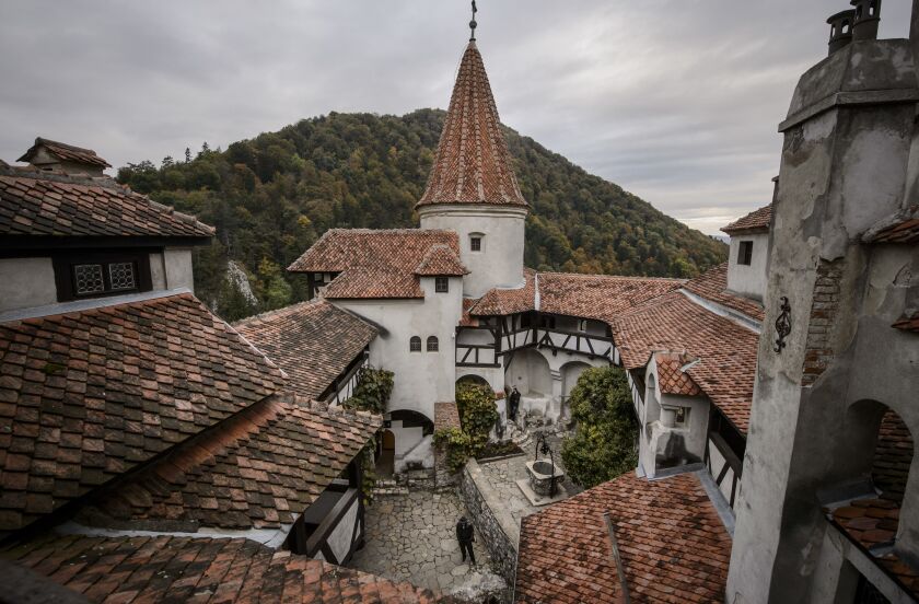 In this picture taken Oct. 9, 2016, men stand in the inner courtyard of Bran Castle, in Bran, Romania. Airbnb has launched a contest to find two people to stay overnight in the castle on Halloween. (AP Photo/Andreea Alexandru)