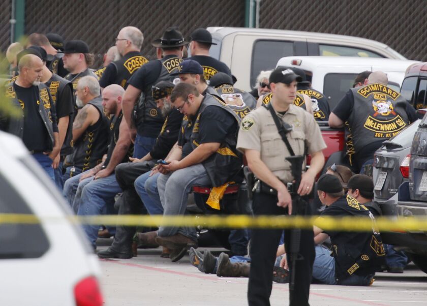 <small><strong>A McLennan County deputy stands guard near a group of bikers in the parking lot of a Twin Peaks restaurant Sunday, May 17, 2015, in Waco, Texas. | Rod Aydelotte / Waco Tribune-Herald via AP</strong></small>