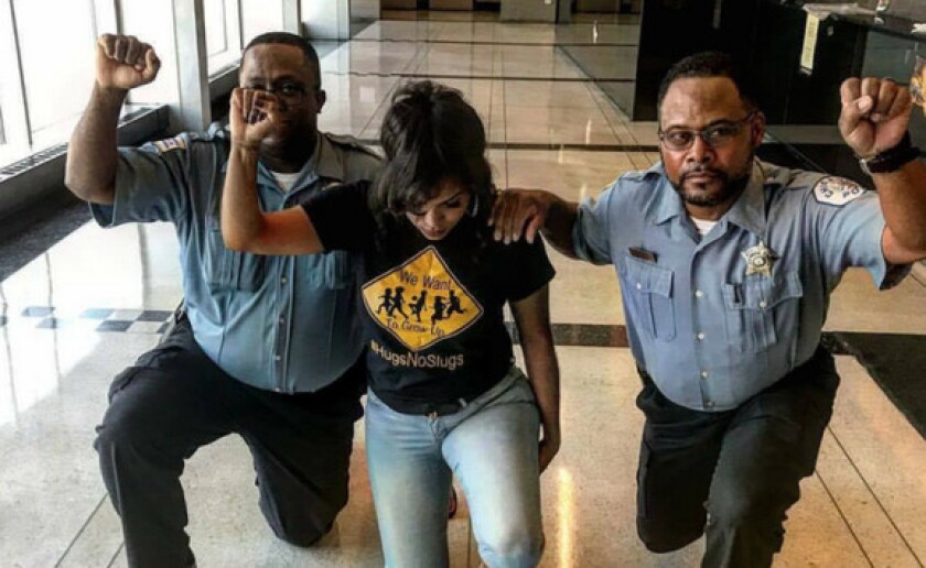 An Instagram account photo of two Chicago Police officers, along with a woman believed to be Aleta Clark, an anti-violence activist in Englewood, “taking a knee.” | Instagram account of @englewoodbarbie