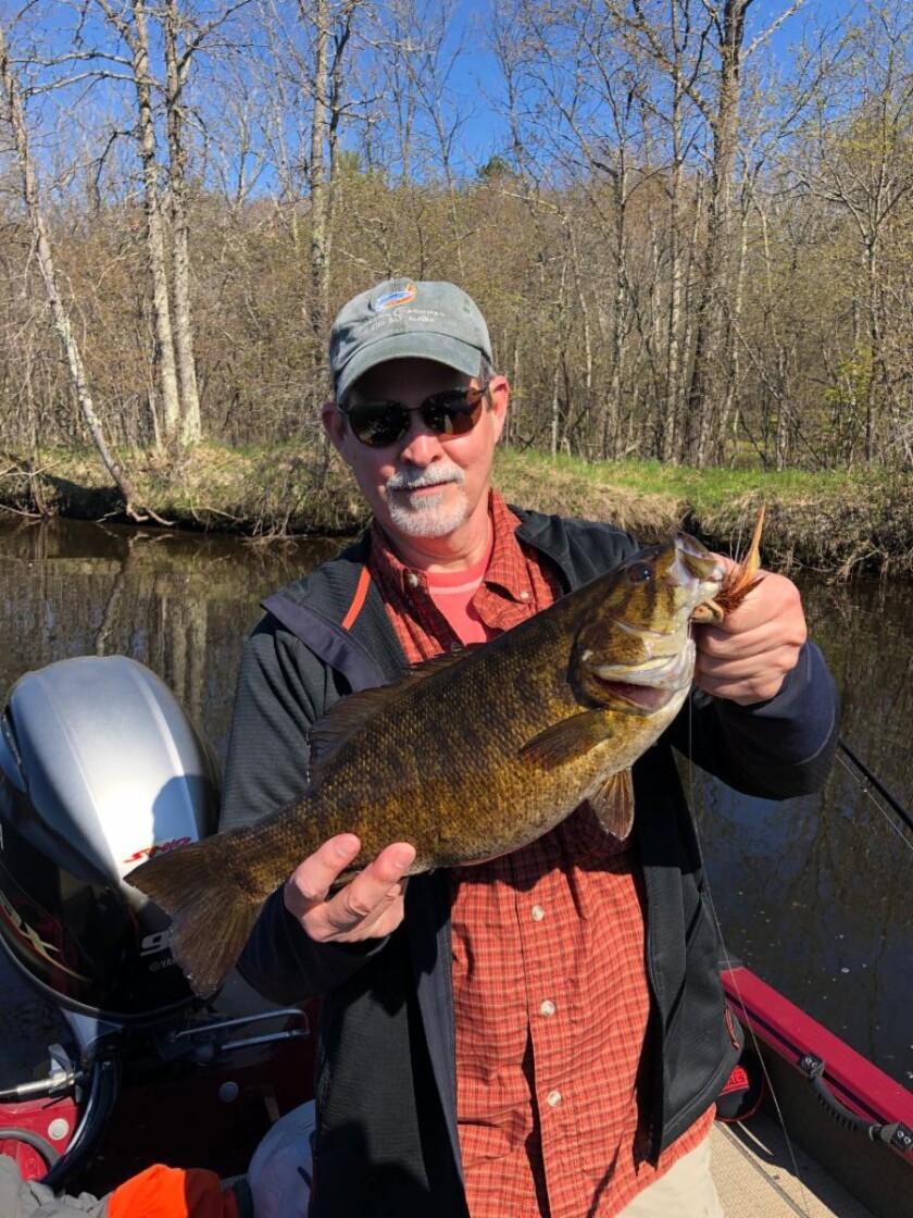 Jeff Miller with 20-inch smallmouth bass caught on a fly rod on the Menominee River. Provided by Mike Mladenik