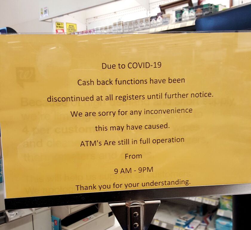 A sign posted at a Walgreens at 75th and State streets said cash back was suspended due to the coronavirus outbreak.