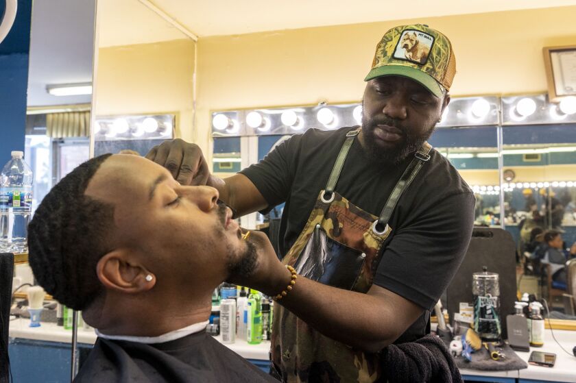Steven Williams, hairstylist and owner of Urban Professional Grooming, cuts Chuck Gordon's hair at Urban Professional Grooming.