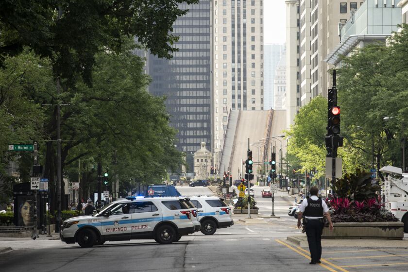 Chicago Police stand guard on the Magnificent Mile and the Michigan Avenue Bridge over the Chicago River is lifted after looting broke out overnight in the Loop and surrounding neighborhoods, Monday morning, Aug. 10, 2020.