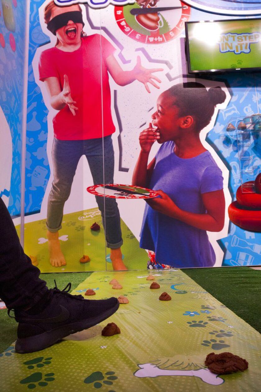 Don’t Step In It from Hasbro has players place mounds of brown compound on the game mat, then take turns spinning the spinner to find out how many steps to take across the mat while blindfolded. | AP Photo