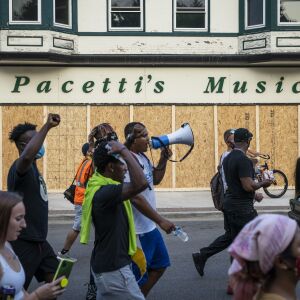 Protesters march by boarded up businesses in Kenosha on the second night of unrest after police shot Jacob Blake, Monday night, Aug. 24, 2020.