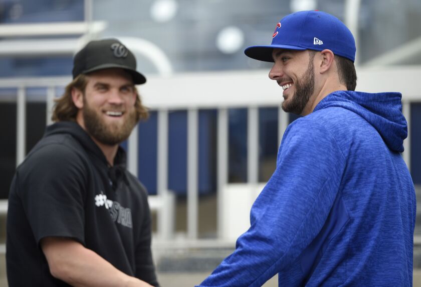 Washington Nationals’ Bryce Harper, left, laughs with Cubs’ Kris Bryant.
