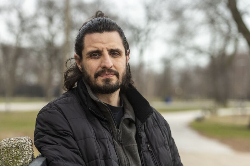 Arturo Carrillo, Director of Health and Violence Prevention with the Brighton Park Neighborhood Council, sits at a bench near a beach in Calumet Park, Friday, March 26, 2021.